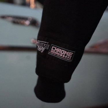 Close-up of a black sleeve with 'Chrome Industries' logo on a blurred background