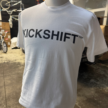 White t-shirt with 'KICKSHIFT' logo on a mannequin in an indoor setting.