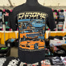 Black t-shirt with car graphic and 'Chrome Festival' text on a mannequin, with a blurred store background.